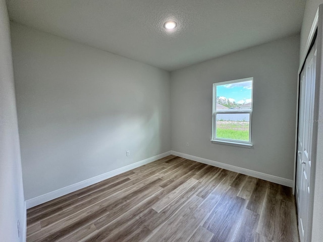 16463 SW 55th Court Rd, Ocala, FL 34473 - unfurnished bedroom with wood finished floors, baseboards, a closet, a textured ceiling, and recessed lighting