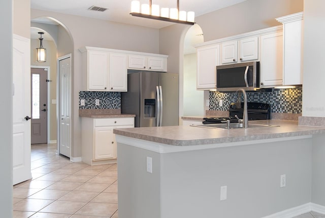 1322 Reagans Reserve Blvd, Apopka, FL 32712 - kitchen featuring appliances with stainless steel finishes, arched walkways, light tile patterned floors, and tasteful backsplash
