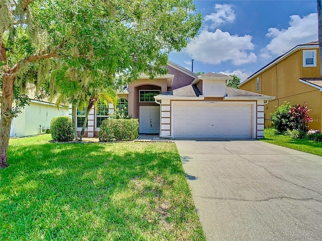 6843 Cherry Grove Cir, Orlando, FL 32809 - view of front of house featuring a front lawn, an attached garage, stucco siding, and driveway