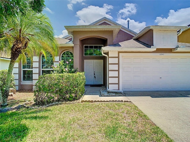 6843 Cherry Grove Cir, Orlando, FL 32809 - view of front of property featuring stucco siding, concrete driveway, a garage, a front lawn, and roof with shingles