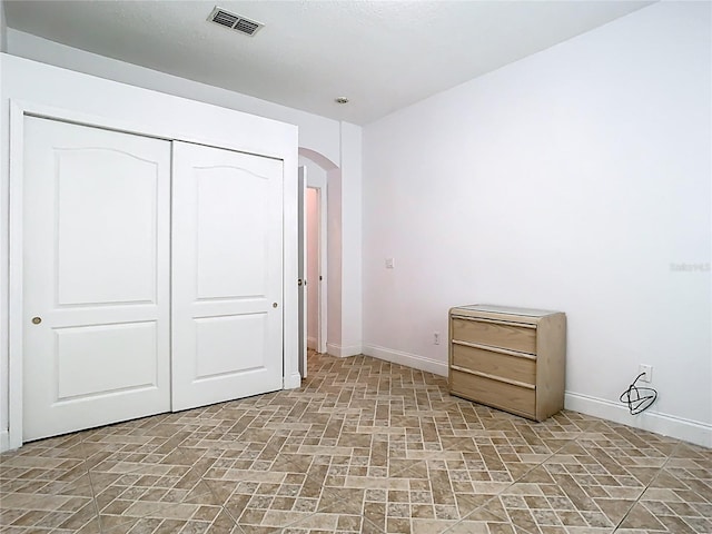 6843 Cherry Grove Cir, Orlando, FL 32809 - unfurnished bedroom with baseboards, arched walkways, and a closet