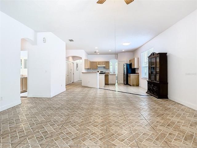 6843 Cherry Grove Cir, Orlando, FL 32809 - unfurnished living room with arched walkways, a ceiling fan, baseboards, and light stone finish flooring