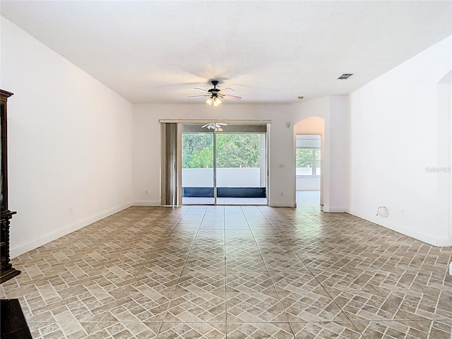 6843 Cherry Grove Cir, Orlando, FL 32809 - empty room featuring arched walkways, a ceiling fan, and baseboards