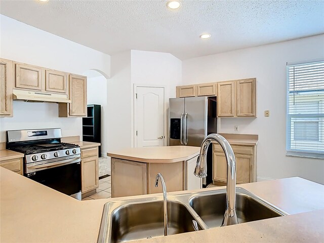 6843 Cherry Grove Cir, Orlando, FL 32809 - kitchen featuring stainless steel appliances, under cabinet range hood, a sink, light brown cabinetry, and a textured ceiling