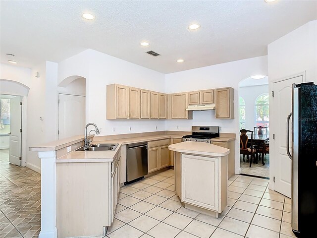 6843 Cherry Grove Cir, Orlando, FL 32809 - kitchen with appliances with stainless steel finishes, a sink, light brown cabinetry, a peninsula, and light countertops
