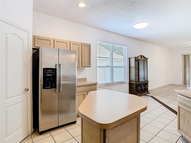 6843 Cherry Grove Cir, Orlando, FL 32809 - kitchen with stainless steel fridge, a kitchen island, light countertops, light tile patterned flooring, and recessed lighting