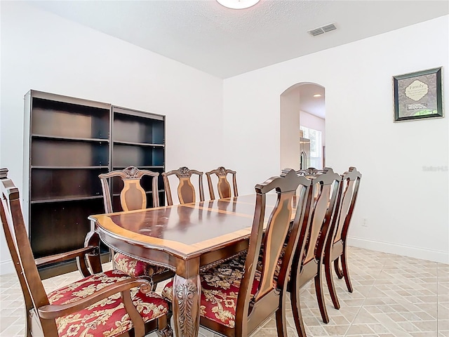 6843 Cherry Grove Cir, Orlando, FL 32809 - dining space with arched walkways, baseboards, and a textured ceiling
