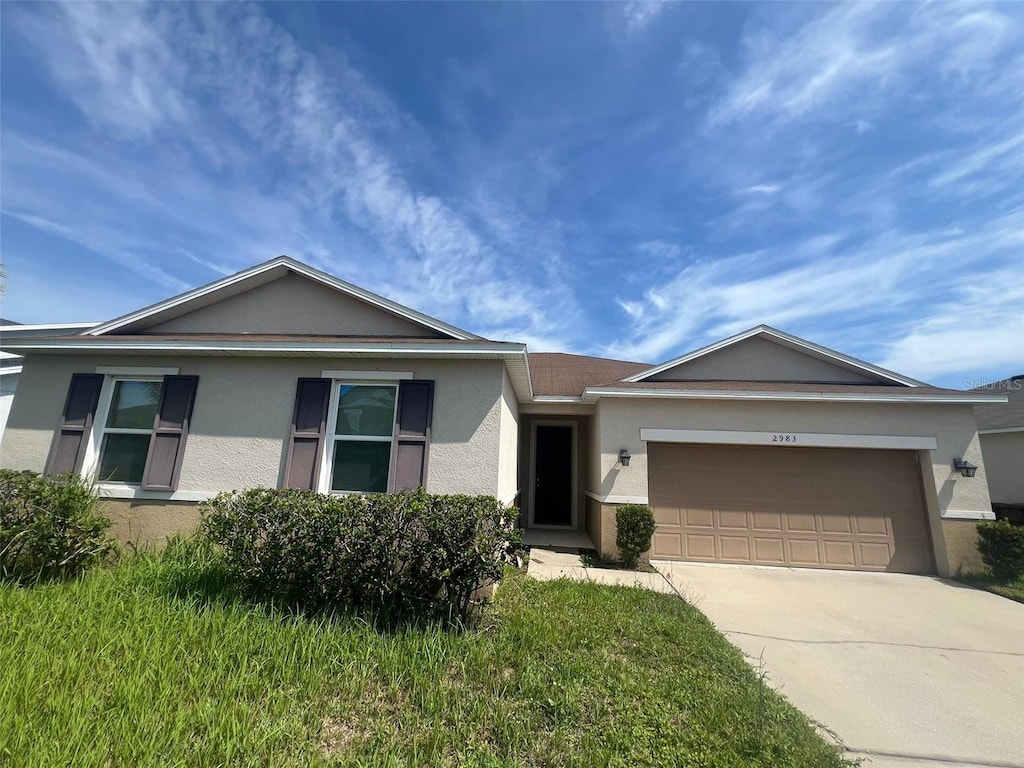 2983 Boating Blvd, Kissimmee, FL 34746 - single story home with stucco siding, an attached garage, and driveway