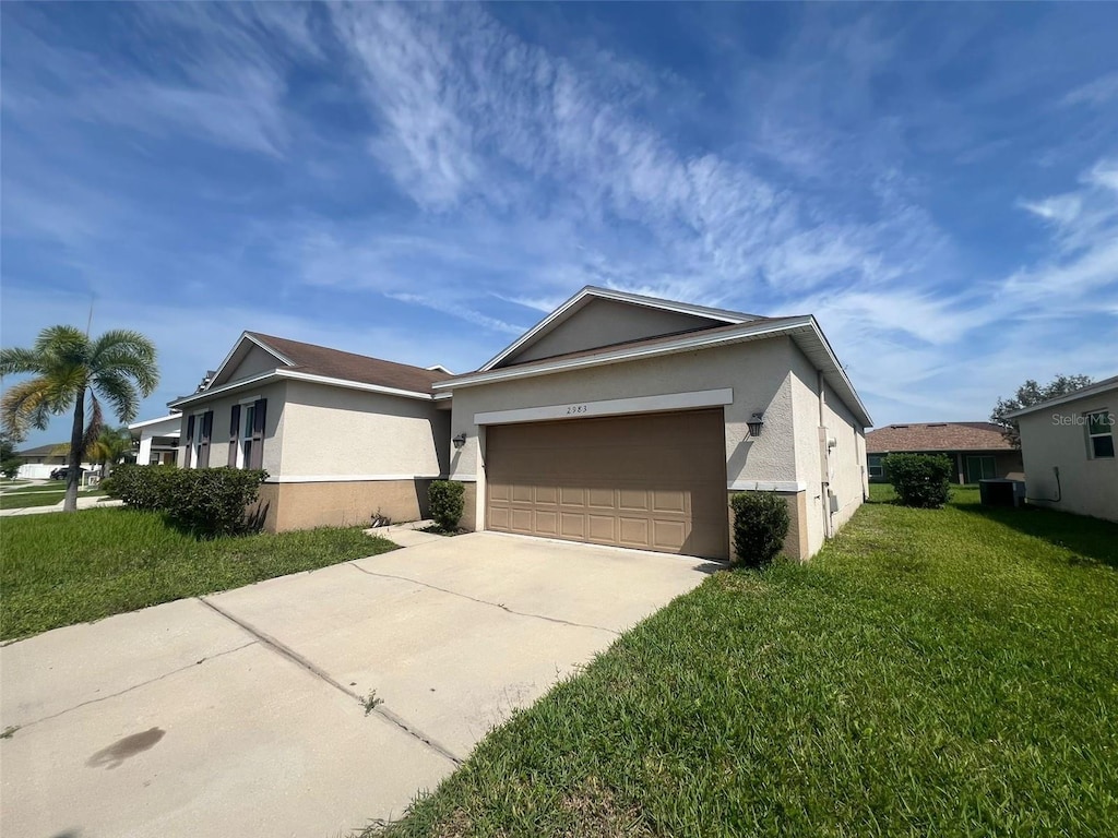 2983 Boating Blvd, Kissimmee, FL 34746 - view of front facade featuring stucco siding, an attached garage, concrete driveway, and a front yard