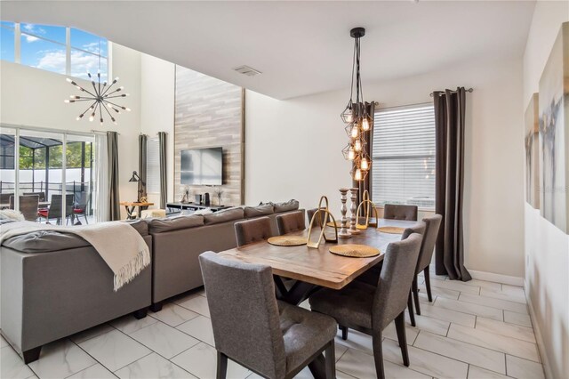 4740 Sleepy Hollow Dr, Kissimmee, FL 34746 - dining room featuring a chandelier, light marble finish flooring, a high ceiling, and baseboards