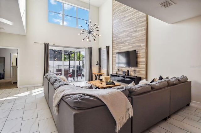 4740 Sleepy Hollow Dr, Kissimmee, FL 34746 - living area with a towering ceiling, a chandelier, and baseboards