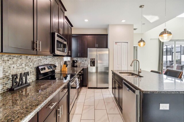 4740 Sleepy Hollow Dr, Kissimmee, FL 34746 - kitchen with appliances with stainless steel finishes, a sink, a center island with sink, dark stone counters, and dark brown cabinetry