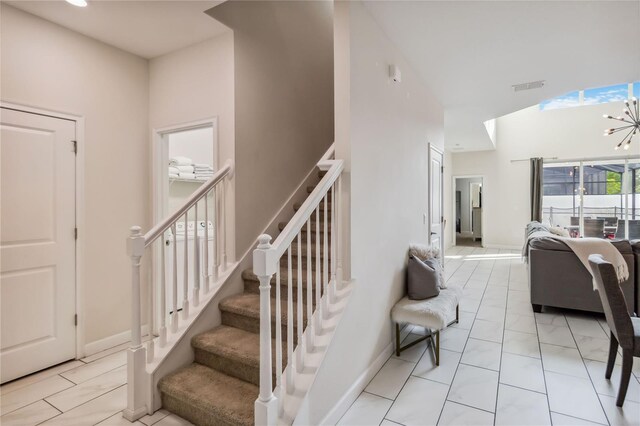 4740 Sleepy Hollow Dr, Kissimmee, FL 34746 - staircase with a towering ceiling, baseboards, and a chandelier