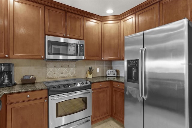 1100 Sunset View Cir Unit 204, Reunion, FL 34747 - kitchen with stainless steel appliances, dark stone countertops, and brown cabinetry