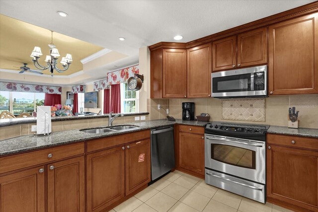 1100 Sunset View Cir Unit 204, Reunion, FL 34747 - kitchen featuring stainless steel appliances, a sink, brown cabinets, a chandelier, and recessed lighting
