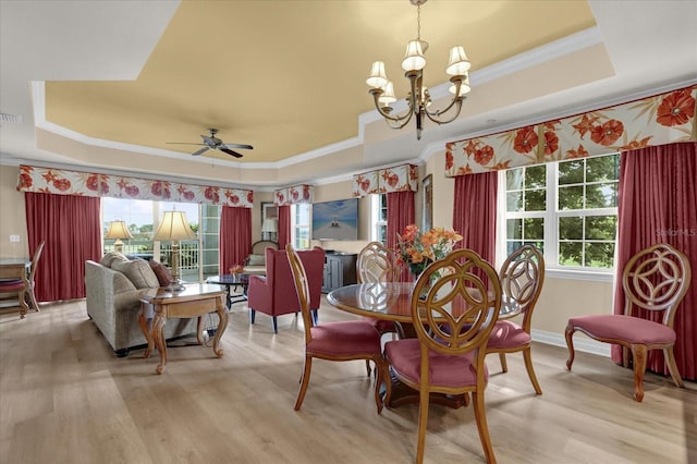 1100 Sunset View Cir Unit 204, Reunion, FL 34747 - dining room featuring a tray ceiling, crown molding, healthy amount of natural light, wood finished floors, and a chandelier