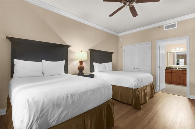 1100 Sunset View Cir Unit 204, Reunion, FL 34747 - bedroom with light wood-type flooring, ornamental molding, a closet, ensuite bath, and ceiling fan