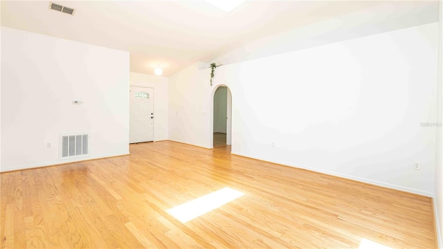 4236 Newtonhall Dr, Orlando, FL 32826 - unfurnished room featuring arched walkways, light wood-style floors, lofted ceiling, and baseboards