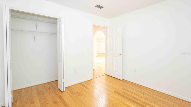 4236 Newtonhall Dr, Orlando, FL 32826 - unfurnished bedroom featuring light wood-style floors, arched walkways, a closet, and baseboards
