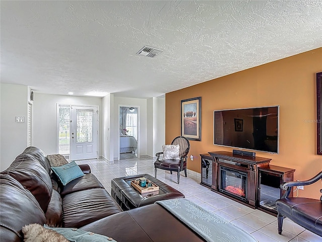 620 Wood Dr, Kissimmee, FL 34759 - living area featuring light tile patterned floors, a textured ceiling, and baseboards