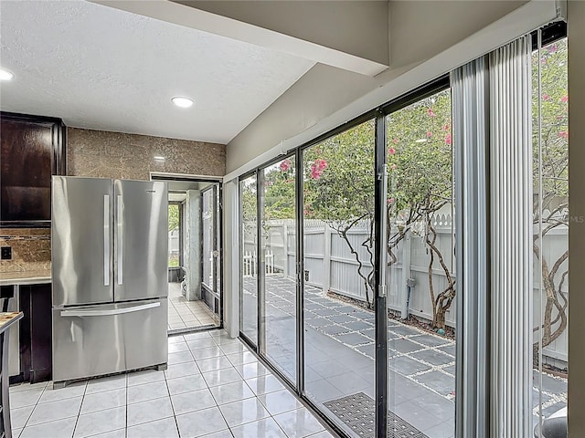 620 Wood Dr, Kissimmee, FL 34759 - kitchen featuring freestanding refrigerator, dark brown cabinets, light tile patterned floors, a textured ceiling, and light countertops