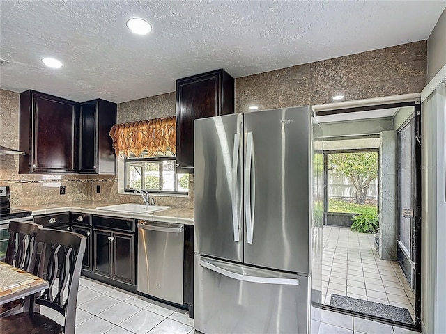 620 Wood Dr, Kissimmee, FL 34759 - kitchen with stainless steel appliances, a sink, light tile patterned floors, light countertops, and tasteful backsplash
