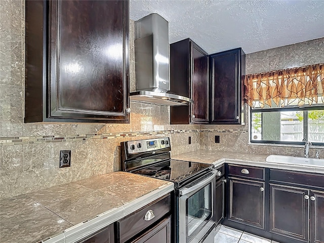 620 Wood Dr, Kissimmee, FL 34759 - kitchen with stainless steel electric range, wall chimney exhaust hood, a sink, tasteful backsplash, and dark brown cabinets
