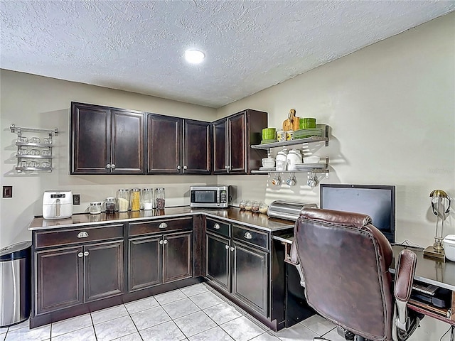 620 Wood Dr, Kissimmee, FL 34759 - kitchen featuring stainless steel microwave, open shelves, light tile patterned floors, a textured ceiling, and dark brown cabinets
