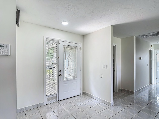 620 Wood Dr, Kissimmee, FL 34759 - entrance foyer featuring light tile patterned flooring, baseboards, and a textured ceiling
