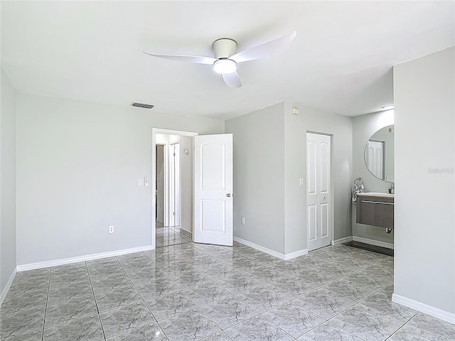 620 Wood Dr, Kissimmee, FL 34759 - unfurnished bedroom featuring baseboards, ceiling fan, arched walkways, and light marble finish floors
