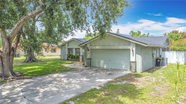 620 Wood Dr, Kissimmee, FL 34759 - ranch-style home featuring an attached garage, concrete driveway, and stone siding