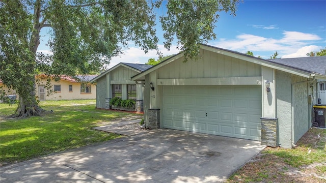 620 Wood Dr, Kissimmee, FL 34759 - single story home with an attached garage, a front lawn, concrete driveway, stone siding, and roof with shingles