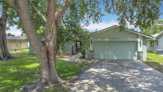620 Wood Dr, Kissimmee, FL 34759 - ranch-style home featuring asphalt driveway, stone siding, a garage, and central air condition unit