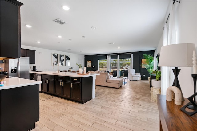 14357 Hidden Ct, Clermont, FL 34711 - kitchen with stainless steel appliances, a sink, light countertops, open floor plan, and a center island with sink
