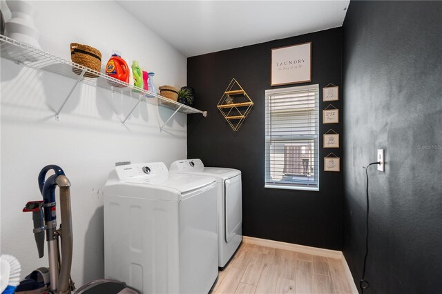 14357 Hidden Ct, Clermont, FL 34711 - washroom featuring washing machine and clothes dryer, light wood finished floors, and baseboards