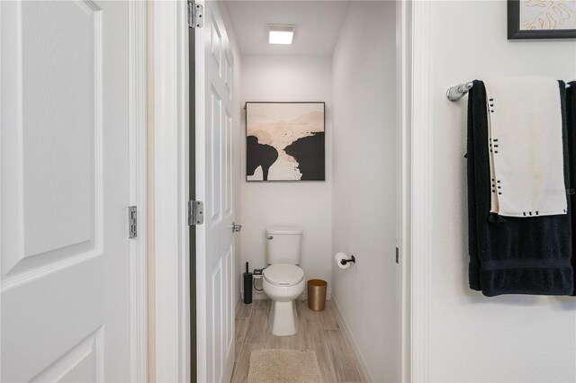 14357 Hidden Ct, Clermont, FL 34711 - bathroom with toilet, wood finished floors, and baseboards