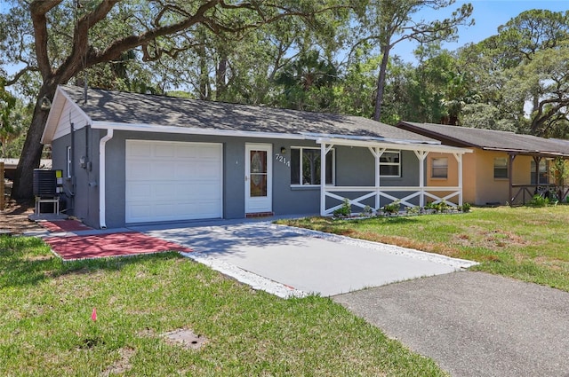 7214 Oakwood Dr, New Port Richey, FL 34652 - ranch-style home featuring a garage, covered porch, driveway, stucco siding, and a front yard