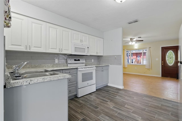 7214 Oakwood Dr, New Port Richey, FL 34652 - kitchen featuring white appliances, a sink, a ceiling fan, light countertops, and decorative backsplash