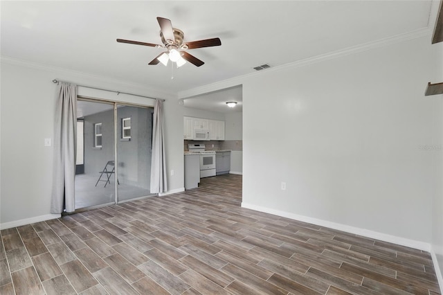 7214 Oakwood Dr, New Port Richey, FL 34652 - unfurnished living room with ceiling fan, wood finished floors, crown molding, and baseboards