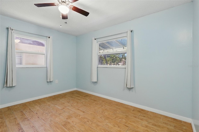 7214 Oakwood Dr, New Port Richey, FL 34652 - unfurnished room with wood finished floors, plenty of natural light, a ceiling fan, and a textured ceiling