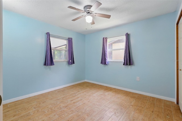 7214 Oakwood Dr, New Port Richey, FL 34652 - spare room with healthy amount of natural light, wood finished floors, a textured ceiling, a ceiling fan, and baseboards