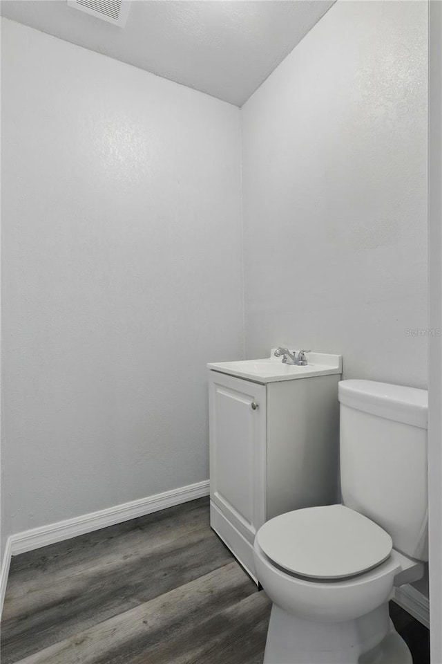 7214 Oakwood Dr, New Port Richey, FL 34652 - bathroom with wood finished floors, vanity, toilet, and baseboards