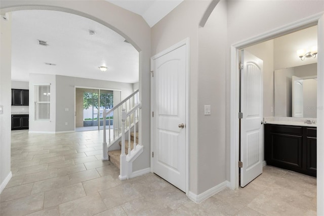 1978 J Lawson Blvd, Orlando, FL 32824 - hallway featuring arched walkways, stairs, baseboards, and light tile patterned flooring