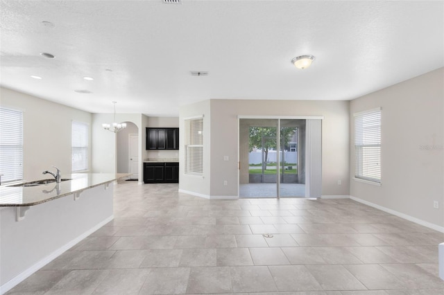 1978 J Lawson Blvd, Orlando, FL 32824 - unfurnished living room with a sink, a chandelier, baseboards, and light tile patterned floors