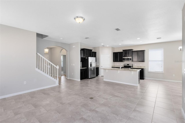 1978 J Lawson Blvd, Orlando, FL 32824 - kitchen with stainless steel appliances, arched walkways, open floor plan, light countertops, and recessed lighting