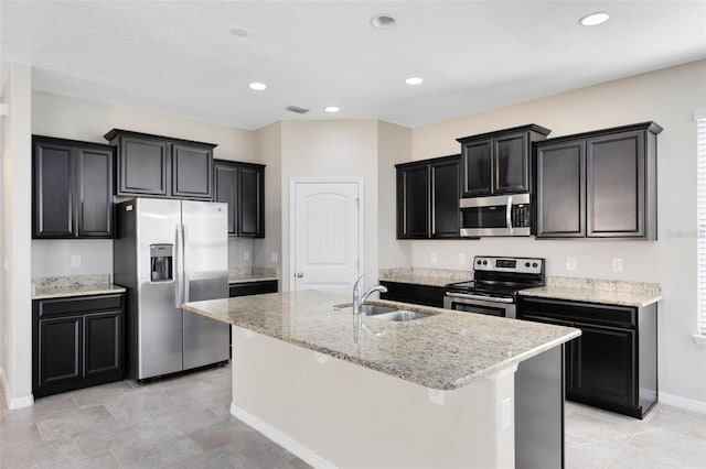 1978 J Lawson Blvd, Orlando, FL 32824 - kitchen with appliances with stainless steel finishes, a sink, an island with sink, dark cabinets, and baseboards