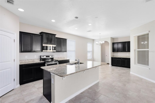 1978 J Lawson Blvd, Orlando, FL 32824 - kitchen featuring stainless steel appliances, a sink, a chandelier, an island with sink, and light stone countertops