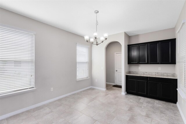 1978 J Lawson Blvd, Orlando, FL 32824 - unfurnished dining area with arched walkways, a chandelier, and baseboards