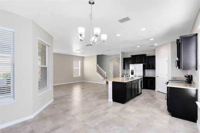 1978 J Lawson Blvd, Orlando, FL 32824 - kitchen with dark cabinets, a sink, arched walkways, stainless steel appliances, and recessed lighting