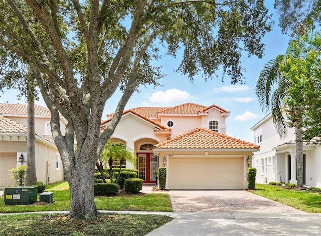 8418 Via Bella Notte, Orlando, FL 32836 - mediterranean / spanish-style house featuring a tiled roof, a garage, driveway, and stucco siding